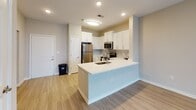 Located at 11275 W Broad St in Glen Allen, VA, this single-floor unit offers a thoughtfully designed open-concept layout with a neutral color palette throughout. The living area features light wood-style flooring and a ceiling fan, with floor-to-ceiling sliding glass doors that invite abundant natural light and provide outdoor views, creating an airy and welcoming atmosphere.

The kitchen is well-appointed with white shaker-style cabinetry, light-toned countertops, and a full suite of stainless steel appliances, including a refrigerator, microwave, electric range, and dishwasher. A peninsula with an integrated sink adds functional prep and dining space while maintaining a seamless flow into the main living area.

The bedrooms feature soft carpeting and neutral walls, with one room offering a ceiling fan with light fixture and a window for natural light. Additional closet space is accessible from within the bedroom areas, offering practical storage solutions.

The bathroom is finished with warm-toned tile flooring and tub surround, complemented by a white vanity with ample cabinetry and a full-size soaking tub with shower. Clean white walls and chrome fixtures complete the polished, functional design of this well-maintained space.