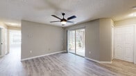 Located at 2109 Polo Club Dr in Kissimmee, Florida, this single-floor, three-bedroom, two-bathroom home offers a well-organized layout with a clean, updated aesthetic throughout. Light wood-style luxury vinyl flooring runs continuously across the living spaces, complemented by neutral gray wall tones and crisp white trim, creating a bright and cohesive interior.

The open living and dining area is anchored by a ceiling fan with integrated lighting and features sliding glass doors that invite natural light and provide direct access to a private patio with outdoor views. The kitchen is thoughtfully appointed with white shaker-style cabinetry, granite-look countertops, a breakfast bar peninsula, and a full suite of stainless steel appliances including a refrigerator, range, microwave, and dishwasher.

The primary bedroom is generously sized and includes its own ceiling fan. All three bedrooms feature the same consistent flooring and neutral palette. The bathrooms echo the home's updated style, showcasing white vanities with granite-look countertops, undermount sinks, black matte hardware, and round framed mirrors. Additional highlights include five closets for ample storage, an in-unit laundry area, and a textured ceiling finish throughout. The overall ambiance is clean, move-in ready, and well-suited for comfortable everyday living.