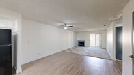Located in Cathedral City, California, this single-story, 2-bedroom, 2-bathroom home offers a well-organized layout with a seamless flow throughout. The open living room is a welcoming central space featuring plush carpeting, a classic fireplace, and a sliding glass door that fills the room with natural light and provides access to the outdoors. A ceiling fan enhances comfort, and the open sightline into the kitchen makes the area feel expansive and connected. The kitchen is thoughtfully designed with two-tone cabinetry — crisp white upper cabinets paired with gray lower cabinets — complemented by stone-look countertops, a gas range, built-in microwave, and a window above the sink that brings in natural light. Light wood-look flooring grounds the space with a clean, modern finish. Both bedrooms are carpeted and feature textured ceilings, vertical blinds, and ample natural light from well-placed windows. The primary bedroom is generously sized and includes a wide sliding-door closet for practical storage. The two bathrooms are clean and functional, each equipped with a tub-shower combination, stone-look countertops, and large mirrors. Overall, the home offers a bright, neutral palette throughout.