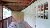 Located at 89 Riverview Dr in Saint Albans, West Virginia, this single-story home offers a practical and comfortable layout suited to everyday living. A standout feature of the property is its covered outdoor deck, which showcases exposed wooden beam construction overhead, providing a rustic, natural aesthetic. The deck is finished with natural wood plank flooring and is enclosed by wooden privacy fencing, creating a sheltered and private outdoor retreat. The exterior of the home is clad in light-colored vinyl siding, and access to the interior is provided through a white paneled door with a glass inset, allowing natural light to filter through. The covered structure of the deck makes it a versatile space, usable in a variety of weather conditions. The combination of exposed timber framing, natural wood tones, and the protective enclosure gives this outdoor area a warm, functional character. Situated in Saint Albans, the property benefits from a community setting in the Kanawha Valley region of West Virginia, offering a blend of residential comfort and natural surroundings.