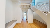 Located in Washington, DC's vibrant Union Market neighborhood, this contemporary two-story residence offers four bedrooms and three bathrooms thoughtfully distributed across two well-proportioned floors. The open-plan kitchen and living area serves as the heart of the home, showcasing dramatic floor-to-ceiling windows that flood the space with natural light and frame expansive views of the DC skyline and surrounding greenery. The sleek, modern kitchen features a large waterfall island with an integrated sink, flat-front white cabinetry reaching to the ceiling, a gas cooktop, and a brass-finish faucet — all finished to a high standard. Light hardwood flooring runs throughout both levels, complementing the clean white walls and exposed beam details in the hallway ceiling. The staircase is a design feature in itself, with a contemporary open-railing system that enhances the sense of openness. Bedrooms are bright and airy, with large black-framed windows offering sweeping urban vistas. The bathrooms are elegantly finished, with large-format tile, soaking tub, and floating vanities with backlit mirrors. A dedicated laundry room houses a stacked Whirlpool washer and dryer alongside a utility sink, adding everyday convenience to this refined, modern home.