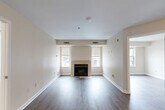 Located at 5816 Westpark Dr in Charlotte, NC, this two-bedroom, two-bathroom residence offers a thoughtfully organized single-floor layout with a neutral color palette and hardwood-style flooring throughout. The living room serves as a central gathering space, highlighted by a classic fireplace flanked by windows that bring in natural light, creating a warm and inviting atmosphere. The kitchen is well-appointed with white shaker-style cabinetry, granite-look countertops, and a full suite of stainless steel appliances including a refrigerator, range, dishwasher, and built-in microwave, all set atop light wood-tone flooring. The spacious primary bedroom features its own closet and connects conveniently to the rest of the unit, while the second bedroom benefits from a large window with exterior views, filling the room with daylight. Both bathrooms are clean and functional, with one featuring a full tub-shower combination with chrome fixtures and wood-style flooring. Additional closets throughout the unit provide ample storage. The overall design is consistent and cohesive, with light beige walls, crisp white trim, and durable flooring choices that lend the space a modern, move-in-ready appeal.