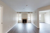 Located at 5816 Westpark Dr in Charlotte, NC, this two-bedroom, two-bathroom residence offers a thoughtfully organized single-floor layout with a neutral color palette and hardwood-style flooring throughout. The living room serves as a central gathering space, highlighted by a classic fireplace flanked by windows that bring in natural light, creating a warm and inviting atmosphere. The kitchen is well-appointed with white shaker-style cabinetry, granite-look countertops, and a full suite of stainless steel appliances including a refrigerator, range, dishwasher, and built-in microwave, all set atop light wood-tone flooring. The spacious primary bedroom features its own closet and connects conveniently to the rest of the unit, while the second bedroom benefits from a large window with exterior views, filling the room with daylight. Both bathrooms are clean and functional, with one featuring a full tub-shower combination with chrome fixtures and wood-style flooring. Additional closets throughout the unit provide ample storage. The overall design is consistent and cohesive, with light beige walls, crisp white trim, and durable flooring choices that lend the space a modern, move-in-ready appeal.