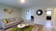 Located at 40 Begonia, this two-floor home offers a well-designed layout that balances comfort and functionality. The main level showcases a bright and open living area finished with smooth hardwood-style flooring that extends throughout the space. Neutral-toned walls create a clean, versatile backdrop that complements a variety of décor styles. The living room flows naturally into a dedicated dining area through an open passageway, allowing for an easy and connected living experience. A wall-mounted decorative mirror accent adds a contemporary touch to the living space, while a floor vent indicates a central HVAC system for year-round climate control. Natural light filters in through the windows, enhancing the airy and welcoming ambiance of the main level. The open-concept connection between living and dining areas makes the space ideal for both everyday living and entertaining. With two floors, the home provides ample room for separate living and private spaces, offering a practical and comfortable arrangement. The consistent flooring and cohesive color palette throughout contribute to a unified and modern aesthetic that defines the overall character of this home.