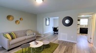 Located at 40 Begonia, this two-floor home offers a well-designed layout that balances comfort and functionality. The main level showcases a bright and open living area finished with smooth hardwood-style flooring that extends throughout the space. Neutral-toned walls create a clean, versatile backdrop that complements a variety of décor styles. The living room flows naturally into a dedicated dining area through an open passageway, allowing for an easy and connected living experience. A wall-mounted decorative mirror accent adds a contemporary touch to the living space, while a floor vent indicates a central HVAC system for year-round climate control. Natural light filters in through the windows, enhancing the airy and welcoming ambiance of the main level. The open-concept connection between living and dining areas makes the space ideal for both everyday living and entertaining. With two floors, the home provides ample room for separate living and private spaces, offering a practical and comfortable arrangement. The consistent flooring and cohesive color palette throughout contribute to a unified and modern aesthetic that defines the overall character of this home.