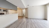 Located in Lakewood, Colorado, this one-bedroom, one-bathroom residence offers a well-designed single-level layout that maximizes functionality and comfort. The open-concept kitchen and living area serves as the heart of the home, featuring a peninsula with light stone countertops that separates the kitchen from the living space. The kitchen is outfitted with gray cabinetry, stainless steel appliances including a refrigerator, range, and microwave, all set atop light wood-style vinyl flooring that runs throughout the main living areas. The living room is bright and inviting, highlighted by a full sliding glass door with vertical blinds that opens to a private patio, allowing natural light to pour in and offering pleasant outdoor views of surrounding greenery. The bedroom is a comfortable retreat with soft carpeting underfoot and multiple windows that provide natural light from multiple angles. A dedicated closet with bifold doors adds convenient storage. The bathroom features a gray vanity with a white countertop and sink, a large mirror with overhead lighting, and a full soaking tub with shower. A hallway connects the living spaces seamlessly, completing this clean and practical floor plan ideal for comfortable everyday living.
