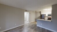 Located at 2200 Montrose Parkway in Peachtree Corners, GA, this one-bedroom, one-bathroom unit offers a well-designed single-floor layout. The open-concept main area seamlessly integrates the living room, dining space, and kitchen, creating a functional and connected environment. The kitchen is outfitted with stainless steel appliances—including a refrigerator, gas range, and microwave—white cabinetry, a tile backsplash, and a granite-topped peninsula with an integrated sink, providing both prep space and a casual dining option. Wood-style plank flooring runs throughout the main living areas, complemented by neutral gray walls and textured ceilings. The living room features a sliding glass door with vertical blinds, opening to an outdoor area and allowing natural light to fill the space. The bedroom is carpeted for comfort and includes two windows for additional natural light, a door leading to an outdoor balcony, and access to a dedicated walk-in closet. A second closet in the hallway provides further storage. The bathroom features a granite-topped vanity with white cabinetry, a large mirror, and a full tub-shower combination with tile surround. The hallway connects all areas efficiently, completing this practical and comfortable layout.