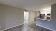 Located at 2200 Montrose Parkway in Peachtree Corners, GA, this one-bedroom, one-bathroom unit offers a well-designed single-floor layout. The open-concept main area seamlessly integrates the living room, dining space, and kitchen, creating a functional and connected environment. The kitchen is outfitted with stainless steel appliances—including a refrigerator, gas range, and microwave—white cabinetry, a tile backsplash, and a granite-topped peninsula with an integrated sink, providing both prep space and a casual dining option. Wood-style plank flooring runs throughout the main living areas, complemented by neutral gray walls and textured ceilings. The living room features a sliding glass door with vertical blinds, opening to an outdoor area and allowing natural light to fill the space. The bedroom is carpeted for comfort and includes two windows for additional natural light, a door leading to an outdoor balcony, and access to a dedicated walk-in closet. A second closet in the hallway provides further storage. The bathroom features a granite-topped vanity with white cabinetry, a large mirror, and a full tub-shower combination with tile surround. The hallway connects all areas efficiently, completing this practical and comfortable layout.