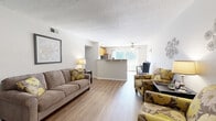 This single-floor, 2-bedroom, 1-bathroom residence offers a practical and comfortable layout across a thoughtfully arranged floor plan. The open-concept living and dining area serves as the heart of the home, featuring warm hardwood-style flooring, a textured ceiling, and a seamless flow toward the kitchen. Natural light filters in through a large window at the far end, complemented by a ceiling fan overhead. The kitchen is equipped with warm-toned wood cabinetry, stainless steel appliances including a refrigerator and dishwasher, and ample counter space.

A welcoming hallway entry with hardwood-style flooring connects the main living areas to the private bedrooms. The spacious primary bedroom features plush carpeting, a generously sized closet with built-in shelving, and a window that allows in natural light. The second bedroom is equally comfortable, with soft carpet flooring and its own window with blinds. The full bathroom includes a vanity with storage, a tub-shower combination, and a classic decorative finish. Throughout the residence, neutral tones and clean lines create a cohesive, functional ambiance suited for everyday living.