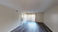 Located at 1333 E Grand in Escondido, Unit J 203 is a single-floor residence that combines modern updates with a clean, functional layout. Throughout the unit, wood-style plank flooring adds warmth and continuity, complemented by neutral-toned walls and textured ceilings.

The open living area is spacious and well-lit, featuring a large sliding glass door fitted with vertical blinds that allows natural light to pour in and provides access to the outdoors. The layout flows seamlessly toward the kitchen, which stands out as a highlight of the unit. It features white shaker-style cabinetry with brushed hardware, dark countertops, a double stainless steel sink, and a full suite of stainless steel appliances including a refrigerator, electric range, and built-in microwave. A window above the countertop brings in additional natural light.

The bedrooms are generously sized, each offering windows with vertical blinds, neutral walls, and the same wood-style flooring found throughout the home. The bathroom is neatly appointed with white cabinetry, dark countertops, a large mirror, and louvered closet doors nearby, maintaining the unit's consistent modern aesthetic. Overall, the space presents a clean, move-in-ready environment with practical updates throughout.