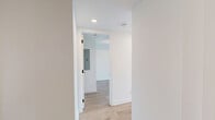 Located at 7 Fairbank Avenue West in Toronto's vibrant Corso Italia neighbourhood, this well-appointed one-bedroom, one-bathroom unit showcases a clean, modern aesthetic throughout. Light-toned hardwood flooring flows seamlessly across the entire space, lending warmth and continuity to the open layout.

The kitchen is thoughtfully designed with a combination of warm wood-toned upper cabinetry and slate-grey lower cabinets, complemented by stainless steel appliances including a full-size refrigerator and dishwasher. Track lighting above the kitchen adds both function and a contemporary industrial touch, while an exposed concrete ceiling detail adds character to the space.

The generously sized bedroom features a large mirrored closet that amplifies natural light and creates a sense of openness, as well as a separate built-in double sliding-door closet. Exposed concrete ceiling elements continue into the bedroom, reinforcing the modern design language. Windows bring in natural light and views of the surrounding neighbourhood.

The bathroom is finished with crisp white subway tile surrounding a soaker tub and shower combination, chrome fixtures, and recessed lighting, delivering a clean, spa-inspired feel. Throughout the unit, white walls, minimalist door hardware in matte black, and consistent flooring tie the design together into a cohesive, contemporary living space.