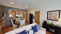 This two-floor residence offers a thoughtfully designed layout that balances comfort and functionality across both levels. The main floor greets visitors with a welcoming entryway featuring hardwood-style flooring, recessed lighting, and a staircase leading to the upper level. The open-concept living area flows seamlessly into a dedicated sitting room bathed in natural light from large windows, creating a bright and inviting atmosphere. An elegant arched passage connects the living space to the kitchen, which is equipped with stone-look countertops, a double-basin sink, warm wood cabinetry, and stainless steel appliances. An adjoining dining area completes the entertaining space on this level. The upper floor hosts multiple carpeted bedrooms, each offering its own character. The primary bedroom features a bold accent wall, generous natural light, and direct access to a walk-in closet. Additional bedrooms are equally well-sized, with ample closet space and access to full bathrooms. Each bathroom is outfitted with a tub-shower combination enclosed by sliding glass doors and a large vanity mirror. Textured ceilings and warm wood-toned door and window trim carry throughout the home, lending a cohesive and polished aesthetic to every room.