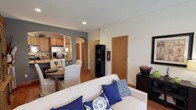 This two-floor residence offers a thoughtfully designed layout that balances comfort and functionality across both levels. The main floor greets visitors with a welcoming entryway featuring hardwood-style flooring, recessed lighting, and a staircase leading to the upper level. The open-concept living area flows seamlessly into a dedicated sitting room bathed in natural light from large windows, creating a bright and inviting atmosphere. An elegant arched passage connects the living space to the kitchen, which is equipped with stone-look countertops, a double-basin sink, warm wood cabinetry, and stainless steel appliances. An adjoining dining area completes the entertaining space on this level. The upper floor hosts multiple carpeted bedrooms, each offering its own character. The primary bedroom features a bold accent wall, generous natural light, and direct access to a walk-in closet. Additional bedrooms are equally well-sized, with ample closet space and access to full bathrooms. Each bathroom is outfitted with a tub-shower combination enclosed by sliding glass doors and a large vanity mirror. Textured ceilings and warm wood-toned door and window trim carry throughout the home, lending a cohesive and polished aesthetic to every room.