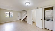 Located at 8330 NW Seventh St in Miami, FL, this two-story, 2-bedroom, 3-bathroom home offers a practical and well-organized layout spread across two floors. Light-colored ceramic tile flooring runs throughout both levels, contributing to a clean, bright aesthetic that complements Miami's sunny climate.

The main floor hosts a combined dining and living area bathed in natural light, an adjacent kitchen equipped with white cabinetry, a range, dishwasher, and a sink with views to the outdoors through vertical blinds. A conveniently located bathroom on this level adds functionality. A staircase with wood-toned steps connects the two floors.

The upper floor houses both bedrooms, including a generously sized primary bedroom, along with two additional bathrooms and a laundry area. Each bedroom features tile flooring, a closet with bifold doors, and windows that let in natural light. The bathrooms are finished with neutral beige tile surrounds and include a soaking tub. With four closets total throughout the home, storage is plentiful. The overall palette of white and warm neutral tones creates a bright, airy atmosphere throughout this well-structured Miami residence.