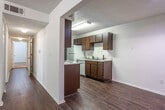 Located at 2908 Birmingham Hwy in Opelika, Alabama, this single-floor unit offers a practical and well-organized layout across several rooms. The living area greets you with rich, dark hardwood-style flooring and a sliding glass door dressed with vertical blinds, allowing natural light to filter in. A dedicated dining or flex area continues the hardwood-style flooring, providing a seamless flow from the main living space.

The galley-style kitchen is efficiently designed with dark wood cabinetry lining both sides, white appliances including a range, refrigerator, and dishwasher, and a double basin sink set beneath a clean white countertop. A textured ceiling adds character throughout the common areas.

Multiple bedrooms are carpeted with plush, neutral-toned carpet and feature windows with blinds that bring in natural light. The primary bedroom includes two generous closets with built-in wire shelving and hanging rods, offering substantial storage. Additional bedrooms are well-proportioned, each with their own closet space. A bathroom with a shower/tub combination and wood-style flooring is conveniently accessible from the bedroom hallway.

Throughout the unit, clean white walls, consistent finishes, and functional HVAC vents contribute to a straightforward and comfortable living environment.