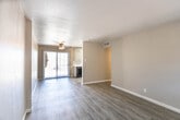 Located at 108 Vaquero Ln in El Paso, Texas, this single-floor residence offers a clean, updated interior with a neutral color palette and modern finishes throughout. The open living area is finished with wood-look vinyl plank flooring and features a ceiling fan with light fixture, a textured ceiling, and a sliding glass door fitted with vertical blinds that allows natural light to pour in and provides direct access to an outdoor patio. The kitchen is laid out in a galley style, featuring gray cabinetry with contemporary hardware, white quartz-style countertops, a classic white subway tile backsplash, a stainless steel sink, and black appliances including a refrigerator, electric range, dishwasher, and overhead exhaust hood. A dedicated entry area greets residents with light-toned vinyl plank flooring and clean white walls. The bedrooms are well-proportioned, each equipped with ceiling fans, natural light from window-blind-covered windows, and consistent vinyl plank flooring. The bathroom includes a full tub-shower combination with white tile surround and a towel bar. Throughout the home, white baseboards and neutral warm-gray walls create a cohesive, move-in-ready aesthetic suited for comfortable everyday living in West El Paso.