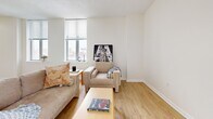 Located at 518 W Fayette St in the heart of Baltimore, MD, this 1-bedroom, 1-bathroom residence offers a thoughtfully designed single-floor layout that makes efficient use of its space. The open-concept living room and kitchen area forms the central hub of the home, bathed in natural light from large windows that offer views of the surrounding cityscape. Light wood-tone flooring runs throughout the main living areas, lending warmth and continuity to the space.

The kitchen features a galley-style layout with warm wood cabinetry, light stone countertops, and a full suite of stainless steel appliances, including a refrigerator, range, microwave, and dishwasher. The living room is generously sized with multiple windows on two walls, allowing abundant natural light and urban views to fill the room.

The spacious primary bedroom is finished with plush carpeting and benefits from corner window placement, providing natural light from multiple directions. A dedicated closet offers practical storage. The full bathroom is finished with neutral tile, a tub-shower combination, and a sleek white vanity with ample counter space and a modern mirror. A hallway connects all rooms, completing this well-organized and comfortable urban residence.