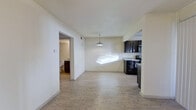 This single-floor unit offers a clean, contemporary layout designed for comfortable everyday living. Light wood-look flooring runs throughout the main living areas, creating a bright and cohesive feel that ties each space together seamlessly.

The open-concept living and dining area is bathed in natural light and anchored by a stylish pendant light fixture that hangs from the ceiling, adding a modern touch. The space flows directly into the kitchen, which is a standout feature of the unit. Dark espresso cabinetry extends from floor to ceiling, providing generous storage, while light granite countertops offer a striking contrast. Stainless steel appliances — including a range, microwave, and refrigerator — along with a stainless sink complete this well-equipped kitchen.

The bedroom is a comfortable, well-proportioned room featuring the same light flooring and a wide double bi-fold closet that offers ample storage. A ceiling fan adds practical comfort to the space.

The bathroom is thoughtfully finished with large-format gray tile surrounding the tub and shower, matching granite countertops on the dark vanity, and a framed mirror — all maintaining the consistent, refined aesthetic found throughout the unit. Clean white walls and neutral tones throughout lend the space a fresh, move-in-ready appeal.