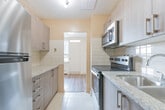 Located at 1470 Williamsport Dr in Mississauga, Ontario, this 2-bedroom, 1-bathroom unit is thoughtfully laid out across a single floor, making efficient use of its space. The living room is a standout feature, characterized by large windows that flood the room with natural light and offer open views of the surrounding neighbourhood, including mature trees and nearby buildings. Warm-toned hardwood-style flooring runs throughout the living areas and bedrooms, lending a cohesive and inviting feel to the space.

The kitchen is positioned off the main living area and features stainless steel appliances, including a full-sized refrigerator, complemented by tiled flooring and white subway tile accents along the walls. Ample cabinetry in a warm wood finish provides practical storage.

Both bedrooms are well-proportioned, featuring the same hardwood-style flooring, neutral wall tones, and windows that bring in natural light. The primary bedroom includes a sliding-door closet, while baseboard heating units ensure comfort throughout.

The bathroom is finished with large-format beige marble-style wall tiles surrounding a full soaker tub and shower combination, accented by chrome fixtures for a clean, polished look. Overall, the unit offers a functional and comfortable layout in a well-established Mississauga location.