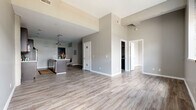 Located at 824 Broadway St in Cincinnati's vibrant downtown, this one-bedroom, one-bathroom unit offers a well-designed open-concept layout finished with consistent light wood-style luxury vinyl flooring throughout. The living area flows seamlessly into the kitchen, which features dark cabinetry, a kitchen island with seating, and a pendant light overhead — ideal for both everyday living and entertaining. Neutral gray walls and crisp white trim create a clean, modern aesthetic throughout the space. The bedroom is generously sized, bathed in natural light through large, industrial-style black-framed windows that frame views of the surrounding Cincinnati cityscape, lending the room an urban loft character. The dedicated closet is outfitted with a built-in organization system, complete with shelving, drawers, and hanging rods, maximizing storage efficiency. The bathroom features dark wood-tone flooring that contrasts with the light tones found in the rest of the unit, lending a warm, grounded feel to the space. With elevated ceilings and a functional single-floor layout, this unit balances contemporary design with practical livability in the heart of downtown Cincinnati.