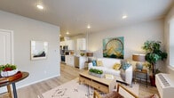 Located at 7995 NE Quatama St in Hillsboro, Oregon, this thoughtfully designed single-floor residence offers three bedrooms and two full bathrooms within a compact yet functional layout. The open-concept living and kitchen area serves as the heart of the home, where light wood-tone flooring, recessed lighting, and a neutral color palette create a clean, welcoming atmosphere. The kitchen features white shaker-style cabinetry, light quartz countertops, a stainless steel sink, and a full suite of stainless steel appliances including a range, microwave, refrigerator, and dishwasher. The adjoining living room receives natural light through a window with outdoor views, providing a comfortable and airy setting. A dedicated entryway area offers a practical transition into the home. The bedrooms are carpeted for comfort, each featuring windows that bring in natural light and views of the surrounding neighborhood. The primary bedroom includes direct exterior access through a glass door. Both bathrooms are finished with white cabinetry, light countertops, and wood-tone flooring; one includes a shower/tub combination, while the other serves as a well-appointed secondary bath. Throughout the home, consistent finishes and a light, neutral palette contribute to a cohesive and modern aesthetic.