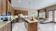 Located at 2001 S Voss Rd in Houston, TX, this thoughtfully designed single-story residence offers a seamless open-concept layout that connects the kitchen, dining, and living areas into one cohesive living space. The kitchen is a standout, showcasing rich warm-toned cabinetry that reaches to the ceiling, granite countertops, stainless steel appliances, and a central island with pendant lighting above — ideal for both everyday cooking and entertaining. A built-in wine rack adds a refined touch. Large-format white tile flooring flows throughout the main living areas, enhancing the sense of brightness and space. The dining area is framed by tall windows with wood blinds and floor-length drapes, allowing for natural light while maintaining privacy. The living room features elevated ceilings and a cozy, intimate layout. The bedroom is carpeted for comfort, with wide windows, a ceiling fan, and direct access to a generously sized walk-in closet outfitted with multi-tier shelving, hanging rods, and a built-in safe. The warm, neutral color palette and consistent design language throughout give this residence a polished, move-in-ready appeal.