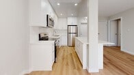 Located at 31 Campbell Crt in Stratford, Ontario, this thoughtfully designed 1-bedroom, 1-bathroom unit offers a clean, modern aesthetic across a single floor. Light-toned hardwood flooring runs throughout the entire space, creating a cohesive and bright atmosphere.

The open-concept kitchen is a standout feature, showcasing white shaker-style cabinetry extending to the ceiling, quartz countertops, a subway tile backsplash, and a full suite of stainless steel appliances including a range, over-the-range microwave, dishwasher, and refrigerator. A peninsula with a quartz countertop provides additional workspace and separates the kitchen from the combined dining and living area. The living space is bathed in natural light from a sliding glass door that opens to an exterior view.

The bedroom is a calm, neutrally toned room with ample natural light and access to generous closet storage, with three closets available throughout the unit. The bathroom features a full soaker tub with white subway tile surround, a single vanity with a white countertop, and clean, minimal finishes. A hallway connects the main living areas to the private spaces. Baseboard heating is present in the living and bedroom areas. The overall ambiance is bright, clean, and move-in ready.