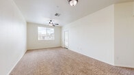 Located at 100 Penzance Ave in Chico, California, this single-story one-bedroom, one-bathroom unit offers a well-organized layout designed for comfortable everyday living. The open-concept living room and kitchen area serves as the heart of the home, featuring warm wood-look hard flooring, dark espresso cabinetry, and a full suite of appliances including a refrigerator, range, microwave, and dishwasher. The spacious living room is carpeted in neutral tones and benefits from abundant natural light streaming through a large window and a glass-paneled exterior door, complemented by a ceiling fan with light fixture overhead. The bedroom is a comfortably sized retreat with plush carpet, a ceiling fan, and a window with blinds that allows natural light while maintaining privacy. A walk-in closet with wire shelving provides generous storage. The bathroom is well-appointed with wood-look flooring, a dark wood vanity with a wide mirror, a tub-shower combination with built-in shelving, and clean white finishes throughout. A hallway connects the rooms with a louvered door leading to additional storage. Crisp white walls and consistent neutral finishes throughout create a clean, cohesive ambiance.