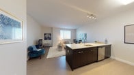 Located at 600 North Beach on Atlantic Avenue in Atlantic City, NJ, this well-designed single-floor residence offers a thoughtfully planned open-concept layout that seamlessly connects the kitchen, dining, and living areas. The kitchen is appointed with dark cabinetry contrasted by crisp white quartz countertops, stainless steel appliances including a refrigerator, microwave, and range, a mosaic tile backsplash, and a central island with an integrated sink — ideal for both cooking and casual dining. Light wood-style flooring flows through the main living space, which is bright and airy thanks to a large window that allows ample natural light to fill the room. The living area provides a comfortable and versatile setting with open sightlines throughout. Two well-proportioned bedrooms feature plush carpeting, generous windows with outdoor views, and neutral tones that create a calm, restful atmosphere. The full bathroom includes a tub-shower combination with tile surround and tile flooring, offering a clean and functional design. The overall aesthetic throughout the unit is modern and cohesive, with a neutral color palette, clean lines, and contemporary finishes that reflect the coastal character of its Atlantic City location.