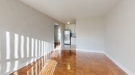 Located at 650 Woodbine Ave in Toronto's Upper Beaches neighbourhood, this well-appointed one-bedroom, one-bathroom unit offers a functional and comfortable layout across a single floor. The entrance opens into a hallway with rich parquet wood flooring that extends throughout the main living areas, lending warmth and character to the space.

The combined dining and living room is generously proportioned, filled with natural light streaming through large windows, and connects seamlessly to the kitchen. The kitchen has been tastefully updated with sleek white cabinetry, dark granite countertops, a grey mosaic tile backsplash, stainless steel appliances including a dishwasher and refrigerator, and tile flooring — offering a clean, modern aesthetic.

The spacious primary bedroom comfortably accommodates a full bedroom suite and features a large window with a radiator beneath it, providing a bright and cozy atmosphere. Three closets throughout the unit offer excellent storage capacity.

The bathroom is finished with classic white tile and a bold black accent stripe, complementing a full soaker tub with a handheld shower. Neutral grey walls throughout the unit create a versatile backdrop, making the space easy to personalize. This unit is ideally situated near the beaches, parks, and transit options of East Toronto.