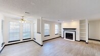 Located at 5300 Highway 138 in Union City, GA, this single-floor, one-bedroom, one-bathroom residence offers a thoughtfully designed layout that maximizes functionality and comfort. The open-concept living and dining area is a standout, featuring light wood-look flooring, a classic fireplace with a bold black mantel and white surround, built-in shelving, and multiple windows that allow natural light to fill the space. A ceiling fan adds comfort, while a textured ceiling and recessed lighting complete the polished look. The kitchen is designed for efficiency, with a galley-style layout featuring dark cabinetry, white countertops, a stainless steel sink, a gas range, and a refrigerator — all unified by a bold, contrasting color palette. A louvered door provides access to a closet within the kitchen area. The bedroom offers comfortable carpeted flooring, a ceiling fan with light, a window with an outdoor view, and ample wall space. Two closets throughout the home provide generous storage. The bathroom is clean and functional, with wood-look tile flooring, a combined tub and shower, toilet, and a dark-cabinetry vanity with a light countertop. Overall, the space presents a cohesive, modern aesthetic with a crisp black-and-white design theme throughout.