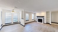 Located at 5300 Highway 138 in Union City, GA, this single-floor, one-bedroom, one-bathroom residence offers a thoughtfully designed layout that maximizes functionality and comfort. The open-concept living and dining area is a standout, featuring light wood-look flooring, a classic fireplace with a bold black mantel and white surround, built-in shelving, and multiple windows that allow natural light to fill the space. A ceiling fan adds comfort, while a textured ceiling and recessed lighting complete the polished look. The kitchen is designed for efficiency, with a galley-style layout featuring dark cabinetry, white countertops, a stainless steel sink, a gas range, and a refrigerator — all unified by a bold, contrasting color palette. A louvered door provides access to a closet within the kitchen area. The bedroom offers comfortable carpeted flooring, a ceiling fan with light, a window with an outdoor view, and ample wall space. Two closets throughout the home provide generous storage. The bathroom is clean and functional, with wood-look tile flooring, a combined tub and shower, toilet, and a dark-cabinetry vanity with a light countertop. Overall, the space presents a cohesive, modern aesthetic with a crisp black-and-white design theme throughout.