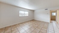 Located at 13214 Bunn Cir in Tampa, FL, this single-story home offers a clean, functional layout finished consistently with light ceramic tile flooring throughout every room. The interior is bright and neutral, with white walls and textured ceilings that lend a classic Florida residential aesthetic.

The living area is open and generously sized, featuring a window fitted with blinds that allows natural light to fill the space. A central hallway connects the main living area to the rest of the home, with a six-panel entry door providing a welcoming focal point near a second window.

The kitchen is well-appointed, showcasing warm honey-toned wood cabinetry that extends to the ceiling for maximum storage. Dark granite-style countertops provide a practical contrast, and the space is equipped with a dishwasher, electric range, and overhead ventilation hood. The tile flooring continues seamlessly from the adjoining living spaces.

The bedrooms are comfortably proportioned, each featuring white walls, tile flooring, and closet access. Crown molding details are present in select rooms, adding a refined touch to the overall design.

The bathroom is efficiently designed with a white vanity offering under-sink storage, a wall mirror, and a shower-tub combination enclosed with a sliding glass door — all finished in a clean, white palette.