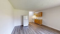This studio in Memphis, TN offers a practical, single-floor layout that efficiently combines the living, dining, and kitchen areas into one open space. The unit features wood-look laminate flooring throughout, lending a clean and cohesive look across the entire space. A textured popcorn ceiling adds a classic touch overhead. The kitchen is equipped with warm-toned wooden cabinetry, a white electric range, a refrigerator, and a sink — providing all essential cooking amenities in a compact, functional arrangement. Natural light filters into the main living area through a large window fitted with vertical blinds, while a wall-mounted HVAC unit ensures year-round climate control. A dedicated closet off the kitchen area provides convenient storage with a built-in shelf and hanging rod. The bathroom features a full tub-and-shower combo with white tile surround, maintaining a simple and clean aesthetic. Neutral white walls throughout keep the space feeling bright and open, making it easy to personalize. This studio is well-suited for individuals seeking a straightforward, functional living space in Memphis.