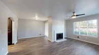 This single-floor residence offers a thoughtfully designed layout with a blend of modern finishes and functional living spaces. The open living area is a standout feature, showcasing dark hardwood-style plank flooring that extends throughout, neutral gray walls, and a ceiling fan overhead. A wood-burning fireplace serves as a central focal point, framed by a clean white surround. Large windows and a sliding glass door with vertical blinds allow generous natural light to fill the space while providing outdoor views and direct exterior access.

The kitchen is well-appointed with rich dark-stained lower cabinetry contrasted by white upper cabinets, white quartz countertops, a subway tile backsplash, and a stainless steel undermount sink — creating a contemporary aesthetic.

The bedrooms feature plush neutral carpeting and multiple windows fitted with blinds, providing ample daylight and outdoor views. Baseboard heating units are present in the bedrooms, ensuring comfort throughout the unit.

The bathrooms are finished cleanly, with one featuring dark vanity cabinetry with white countertops, wood-style flooring, and a tub-shower combination. The second bathroom similarly features a tub-shower unit with chrome fixtures and a streamlined, bright design.