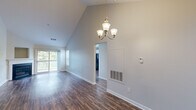 Located at 16 Forest Glen Cir in Middletown, CT, this single-floor, 3-bedroom, 2-bathroom home offers a well-designed layout with notable architectural character. The living room stands out with soaring vaulted ceilings, an elegant chandelier, and rich hardwood-style flooring that extends throughout the main living areas. A corner fireplace serves as a focal point, complemented by a sliding glass door that opens to a private outdoor deck with scenic wooded views, flooding the space with natural light. The kitchen is outfitted with white shaker cabinetry, dark countertops, a classic subway tile backsplash, and black appliances, including a refrigerator, range, and dishwasher. A sliding door in the kitchen also provides convenient deck access. The generously sized primary bedroom features plush carpeting, while the additional bedrooms offer comfortable proportions, soft carpet flooring, and natural light through large windows with wooded outlooks. Both bathrooms include full tub-shower combinations, with one bathroom showcasing a white vanity with granite-style countertops and tile flooring. Throughout the home, clean neutral tones and bright white trim create a cohesive, welcoming ambiance suited for comfortable everyday living.