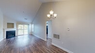 Located at 16 Forest Glen Cir in Middletown, CT, this single-floor, 3-bedroom, 2-bathroom home offers a well-designed layout with notable architectural character. The living room stands out with soaring vaulted ceilings, an elegant chandelier, and rich hardwood-style flooring that extends throughout the main living areas. A corner fireplace serves as a focal point, complemented by a sliding glass door that opens to a private outdoor deck with scenic wooded views, flooding the space with natural light. The kitchen is outfitted with white shaker cabinetry, dark countertops, a classic subway tile backsplash, and black appliances, including a refrigerator, range, and dishwasher. A sliding door in the kitchen also provides convenient deck access. The generously sized primary bedroom features plush carpeting, while the additional bedrooms offer comfortable proportions, soft carpet flooring, and natural light through large windows with wooded outlooks. Both bathrooms include full tub-shower combinations, with one bathroom showcasing a white vanity with granite-style countertops and tile flooring. Throughout the home, clean neutral tones and bright white trim create a cohesive, welcoming ambiance suited for comfortable everyday living.