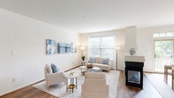 Located at 1 Applewood Drive in Perkasie, PA, this well-appointed three-bedroom, three-bathroom home spans three thoughtfully designed floors. The main level serves as the heart of the home, featuring an open-concept kitchen, dining, and living area. The kitchen is outfitted with warm honey-toned cabinetry, granite countertops, stainless steel appliances, and hardwood-style flooring. The adjacent dining area is bathed in natural light from a sliding glass door that opens to an outdoor deck overlooking a tree-lined neighborhood. The living room features a fireplace and large windows that invite abundant natural light. Upstairs, the generously sized primary bedroom impresses with soaring vaulted ceilings, a ceiling fan, plush carpeting, and ample natural light. The en-suite bathrooms are finished with warm wood vanities, tile flooring, and well-lit mirrors. A second bedroom on this level also benefits from vaulted ceilings and a ceiling fan. The lower level offers a spacious carpeted family room with recessed lighting, ideal for recreation or relaxation, along with a utility room. A private deck at the entrance provides pleasant views of the surrounding greenery, completing this comfortable multi-floor home.
