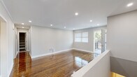 This single-floor residence offers a thoughtfully designed layout with a clean, modern aesthetic throughout. The main living area is bright and open, showcasing richly polished hardwood floors that reflect natural light streaming in through windows and a glass door leading to a private balcony — an ideal spot for outdoor relaxation. Recessed lighting illuminates the space evenly, complementing the neutral gray-toned walls and crisp white crown molding and baseboards.

The kitchen is well-equipped, featuring dark espresso shaker-style cabinetry, white countertops, a classic subway tile backsplash, and a full suite of stainless steel appliances including a gas range, built-in microwave, and dishwasher. Light-toned flooring ties the kitchen together with a fresh, contemporary feel.

The bedrooms continue the hardwood flooring theme and are finished with crown molding. One bedroom features a reach-in closet with bifold doors, while another benefits from dual windows that flood the room with natural light.

The bathroom is elegantly appointed with large-format gray floor tiles, marble-patterned wall surround around the tub and shower, and a dark wood vanity with modern brushed nickel hardware. The entry foyer features light tile flooring and a secure front door, providing a welcoming transition into the home.