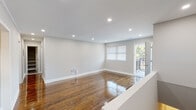 This single-floor residence offers a thoughtfully designed layout with a clean, modern aesthetic throughout. The main living area is bright and open, showcasing richly polished hardwood floors that reflect natural light streaming in through windows and a glass door leading to a private balcony — an ideal spot for outdoor relaxation. Recessed lighting illuminates the space evenly, complementing the neutral gray-toned walls and crisp white crown molding and baseboards.

The kitchen is well-equipped, featuring dark espresso shaker-style cabinetry, white countertops, a classic subway tile backsplash, and a full suite of stainless steel appliances including a gas range, built-in microwave, and dishwasher. Light-toned flooring ties the kitchen together with a fresh, contemporary feel.

The bedrooms continue the hardwood flooring theme and are finished with crown molding. One bedroom features a reach-in closet with bifold doors, while another benefits from dual windows that flood the room with natural light.

The bathroom is elegantly appointed with large-format gray floor tiles, marble-patterned wall surround around the tub and shower, and a dark wood vanity with modern brushed nickel hardware. The entry foyer features light tile flooring and a secure front door, providing a welcoming transition into the home.