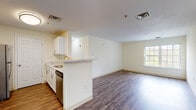Located at 4133 Arbor Dr in Shrewsbury, Massachusetts, this single-floor residence offers a thoughtfully designed layout that balances comfort and functionality. The open-concept living and dining area is anchored by rich hardwood-style flooring that extends throughout the main living spaces, creating a warm and cohesive aesthetic. Natural light filters in through multiple windows, enhancing the bright, neutral color palette found throughout the unit.

The kitchen is equipped with white cabinetry, stainless steel appliances including a dishwasher and refrigerator, and a marble-style countertop that extends to a peninsula, providing a convenient breakfast bar that opens directly to the living area. A dedicated entryway with hardwood-style flooring offers a welcoming transition into the space.

The bedrooms are finished with plush carpeting and feature generous windows with outdoor views of the surrounding greenery. One bedroom includes access to a private balcony via sliding glass doors, while another benefits from a walk-in closet with built-in shelving. The bathroom is clean and functional, featuring a white vanity, a full soaking tub with shower, and hardwood-style flooring, completing this well-rounded residence.