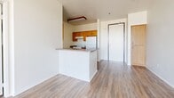 Located at 38832 Fourth St E in Palmdale, CA, this single-floor, two-bedroom, two-bathroom unit offers a well-organized and functional layout. Throughout the home, wood-look vinyl flooring provides a clean, cohesive aesthetic that ties each room together.

The kitchen is designed in a galley style, featuring warm honey-toned wood cabinetry on both sides, dark laminate countertops, a double-basin sink, and white appliances including a range and refrigerator. A peninsula counter opens toward the living area, providing a natural transition between the kitchen and main living space, which is bright and open with neutral white walls.

Both bedrooms feature light-toned wood-look flooring and white walls that maximize the sense of brightness. The primary bedroom offers a comfortable footprint with a dedicated closet, while the second bedroom benefits from a large window that invites natural light and outdoor views. Each bedroom is served by its own dedicated closet for added storage.

The two bathrooms reflect a consistent design language: warm wood vanity cabinetry, dark countertops, and wood-look flooring. One bathroom includes a glass-enclosed shower stall, while the second features a full tub-shower combination with a curved curtain rod. Both are clean, functional, and well-appointed.