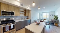 Located at 4949 Baltimore Dr in La Mesa, California, this thoughtfully designed single-story residence showcases a clean, modern aesthetic throughout. The open-concept kitchen and living area serves as the heart of the home, featuring two-tone cabinetry with warm wood upper cabinets and sleek gray lower cabinets, white quartz countertops, a subway tile backsplash, and a full suite of stainless steel appliances including a gas range, built-in microwave, dishwasher, and a large side-by-side refrigerator. A central island with pendant lighting adds both function and style, flowing naturally into the bright living room, which opens to a private balcony with scenic views of the surrounding La Mesa hillside. Light wood-tone flooring runs throughout the main living areas, enhancing the airy, contemporary feel. The bedrooms are well-appointed with large windows that bring in abundant natural light and offer picturesque outdoor views. Each bathroom features white quartz vanity tops, undermount sinks, taupe cabinetry, and large wall mirrors, conveying a clean and modern finish. The overall design balances functionality and modern elegance, making this La Mesa residence a comfortable and visually appealing space.