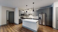 This well-appointed single-floor residence showcases a contemporary design with rich hardwood-style flooring and a neutral color palette carried consistently throughout. The heart of the home is an open-concept kitchen, thoughtfully designed with gray shaker-style cabinetry, a striking herringbone tile backsplash, and a full suite of stainless steel appliances including a range, microwave, dishwasher, and French door refrigerator. A generously sized center island with a clean white quartz countertop offers additional workspace and serves as a natural gathering point. Dramatic black pendant lights hang above the island, complemented by adjustable track lighting overhead. The kitchen flows seamlessly into a spacious living area, which features a ceiling fan and direct access to a private outdoor balcony through large glass French doors, allowing natural light to fill the space. The bedrooms are comfortably sized, each with windows fitted with blinds and ceiling fixtures. The bathrooms are finished in a clean, modern style — one featuring a gray vanity with a framed mirror, and another with a soaking tub and shower combination with a curved curtain rod. Gray door trim and baseboards provide a cohesive, polished finish throughout the entire unit.