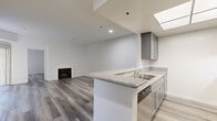 This contemporary 820 square foot apartment in Los Angeles offers a harmonious blend of style and functionality. The open-concept design creates a seamless flow between the living areas, enhancing the sense of space. The kitchen is a standout feature, boasting sleek gray cabinetry, granite countertops, and stainless steel appliances, including a full-size refrigerator and dishwasher.

Both bathrooms are thoughtfully designed with modern vanities, granite countertops, and glass-enclosed showers. The primary bedroom, measuring 140 square feet, provides ample space for rest and relaxation. Large windows and a balcony allow natural light to flood the interior, creating a bright and airy atmosphere.

Throughout the apartment, neutral tones and high-quality finishes prevail. The flooring is a sophisticated gray wood-look material that unifies the space. A fireplace in the living room adds a cozy touch. The apartment's layout includes two closets for storage and a convenient hallway connecting the rooms.

This single-story residence combines urban sophistication with practical living, making it an ideal choice for those seeking a modern lifestyle in the heart of Los Angeles.