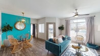 This thoughtfully designed single-floor residence combines bold style with practical living. The open-concept living and dining area immediately captivates with rich wood-look flooring that flows throughout the entire space. A striking teal accent wall anchors the dining area, complemented by a statement gold chandelier and glass-top table, while the living room benefits from abundant natural light streaming through large sliding glass doors that open to an outdoor view. A ceiling fan adds comfort to the airy space.

The kitchen is outfitted with stainless steel appliances, including a full-size refrigerator, range, and built-in microwave, alongside dark wood cabinetry and light countertops, offering ample storage and prep space under track lighting.

The primary bedroom features a bold geometric accent wall paired with dramatic woven pendant lights, creating a boutique hotel ambiance. A second bedroom provides a calm, light-filled retreat with natural light from a vertical window. Both rooms share access to a full bathroom with a wide vanity, extended countertop, and a tub-shower combination.

A spacious walk-in closet with dual hanging rods and shelving provides generous storage. Rounding out the home is a dedicated in-unit laundry room with a full-size washer and dryer.