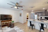 Located at 9103 Gabbro Lane in Boiling Springs, SC, this well-designed 1-bedroom, 1-bathroom single-floor unit offers a practical and modern layout with stylish finishes throughout. Light wood-tone flooring runs continuously across all rooms, creating a cohesive and airy feel. The open-concept kitchen and living area forms the heart of the unit, with the kitchen showcasing rich dark cabinetry, stainless steel appliances — including a refrigerator, range, and dishwasher — and a granite-topped peninsula with bar seating illuminated by a pendant light. The living area is bright and comfortable, featuring a ceiling fan with light and a large window that invites natural light. The bedroom is a well-proportioned retreat with its own ceiling fan, a window with exterior access, and light-filled walls that keep the space feeling open. The full bathroom continues the home's neutral palette with dark wood cabinetry, a single vanity with a white countertop, and hardwood-style flooring. A dedicated utility room rounds out the layout, adding practical storage and functionality. Throughout the unit, clean white walls, modern fixtures, and consistent flooring choices create a cohesive, contemporary aesthetic well-suited for comfortable everyday living.