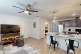 Located at 9103 Gabbro Lane in Boiling Springs, SC, this well-designed 1-bedroom, 1-bathroom single-floor unit offers a practical and modern layout with stylish finishes throughout. Light wood-tone flooring runs continuously across all rooms, creating a cohesive and airy feel. The open-concept kitchen and living area forms the heart of the unit, with the kitchen showcasing rich dark cabinetry, stainless steel appliances — including a refrigerator, range, and dishwasher — and a granite-topped peninsula with bar seating illuminated by a pendant light. The living area is bright and comfortable, featuring a ceiling fan with light and a large window that invites natural light. The bedroom is a well-proportioned retreat with its own ceiling fan, a window with exterior access, and light-filled walls that keep the space feeling open. The full bathroom continues the home's neutral palette with dark wood cabinetry, a single vanity with a white countertop, and hardwood-style flooring. A dedicated utility room rounds out the layout, adding practical storage and functionality. Throughout the unit, clean white walls, modern fixtures, and consistent flooring choices create a cohesive, contemporary aesthetic well-suited for comfortable everyday living.