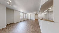 Located at 3644 S Fort Apache Rd in Las Vegas, NV, this one-bedroom, one-bathroom unit offers a thoughtfully designed single-floor layout. The open-concept living, dining, and kitchen area forms the heart of the unit, featuring light wood-style flooring, crisp white walls, and a bank of vertical-blind-covered windows that flood the space with natural light. Track lighting overhead adds a functional, modern touch.

The kitchen is well-appointed with warm-toned wooden cabinetry, granite-style countertops, and a full suite of white appliances including a gas range, dishwasher, refrigerator, and microwave. A raised breakfast bar connects the kitchen seamlessly to the dining and living areas.

The bedroom offers plush carpeting, a ceiling fan, and windows with vertical blinds that bring in additional natural light. A dedicated walk-in closet provides generous storage. The bathroom features a full tub-shower combination with tiled surround, a large vanity mirror, warm cabinetry, and matching granite-style countertops.

Additional conveniences include an in-unit laundry area and a hallway connecting all rooms efficiently. The overall design is clean, neutral, and move-in ready, offering a comfortable and practical living environment.