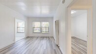 Located at 1227 S Central Ave in Glendale, CA, this 2-bedroom, 1-bathroom unit offers a thoughtfully designed single-floor layout with clean, modern finishes throughout. Light wood-style luxury vinyl flooring runs through the living areas and bedrooms, complementing the crisp white walls and creating a bright, cohesive aesthetic.

The spacious primary bedroom is the largest room in the unit, featuring multiple windows with garden views, a textured shiplap-style ceiling, a built-in wall heater, and direct access to a well-appointed closet with built-in cabinetry and drawers. The second bedroom is equally bright, with a window overlooking lush greenery, white walls, and the same light flooring.

The kitchen stands out with its contemporary renovation, showcasing white shaker cabinets with matte black hardware, marble-look quartz countertops, a large undermount sink with a black pull-down faucet, polished marble-tile flooring, and stainless steel appliances including a gas range and microwave. The bathroom maintains the clean design language with marble-tile flooring, a pedestal sink with a black faucet, a full bathtub, and a wall-mounted mirror. Natural light flows throughout the unit, enhancing its fresh and inviting atmosphere.